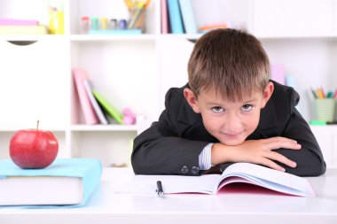 школяр, сидячи на столі в класі