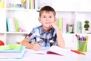 школяр, сидячи на столі в класі