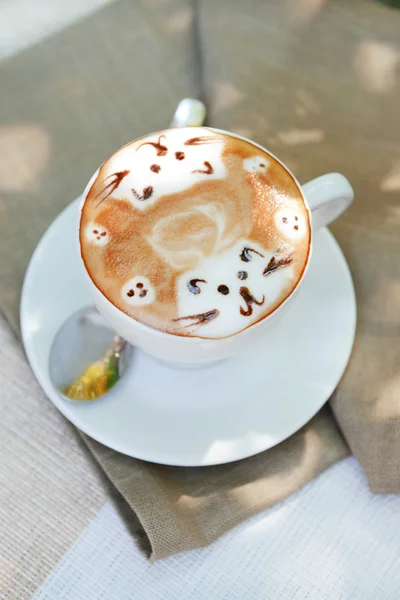 Tasse Kaffee mit niedlicher Zeichnung auf dem Tisch, Nahaufnahme — Stockfoto