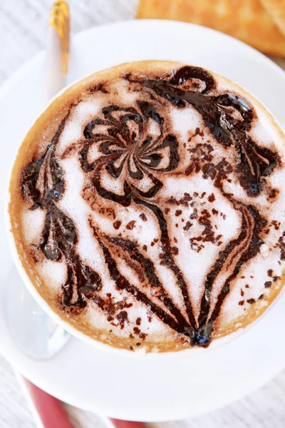 Kopje koffie met schattige puttend uit tabel, close-up — Stockfoto