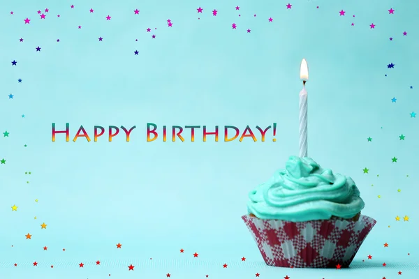 Delicioso cupcake de aniversário na mesa no fundo verde claro — Fotografia de Stock