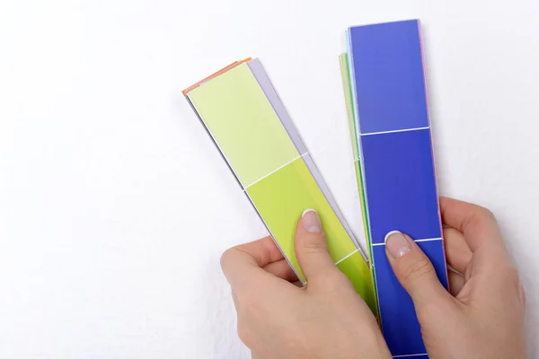 Woman choosing color for wall from swatches in room — Stock Photo, Image