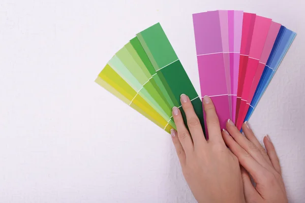 Woman choosing color for wall from swatches in room — Stock Photo, Image