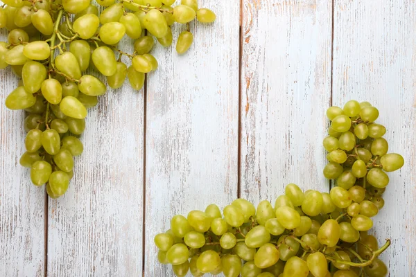 Bunch of ripe grapes on grey wooden background — Stock Photo, Image