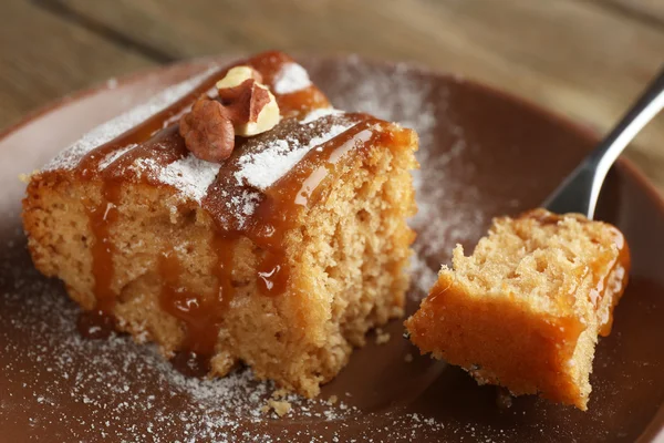 Полусъеденный вкусный кусок торта на тарелке на деревянном столе — стоковое фото