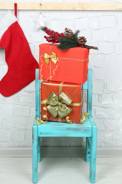 Regalos de Navidad en silla azul sobre fondo de pared de ladrillo — Foto de Stock