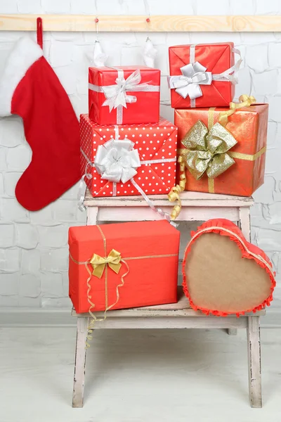 Christmas presents on ladder on brick wall background — Stock Photo, Image