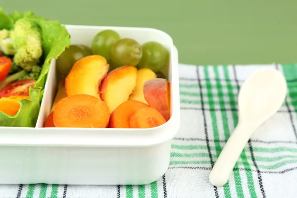 Smaczne potrawy wegetariańskie w plastikowe pudełko na zielony Stół drewniany — Zdjęcie stockowe