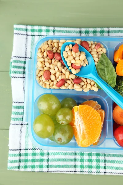 Smakelijke vegetarische maaltijden in plastic doos op groene houten tafel — Stockfoto