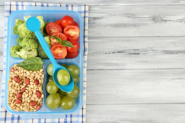 Leckeres vegetarisches Essen in Plastikbox auf Holztisch — Stockfoto