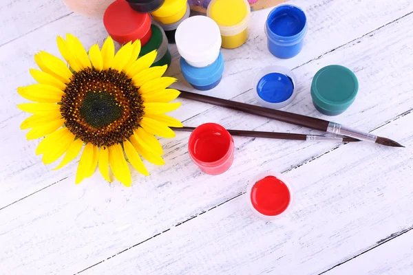 Paints, brushes and sunflower — Stock Photo, Image