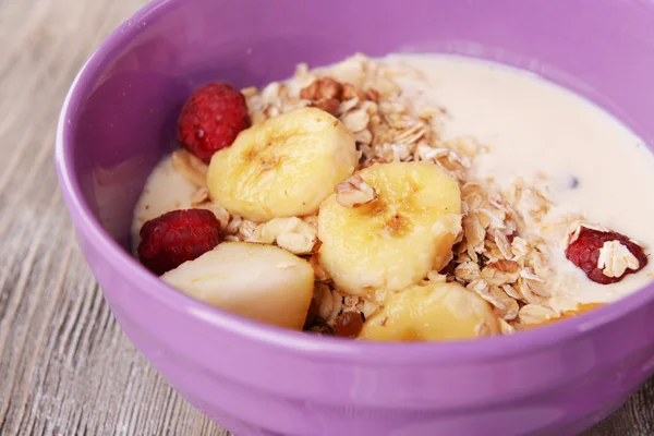 Muesli con leche sobre mesa sobre fondo de madera —  Fotos de Stock