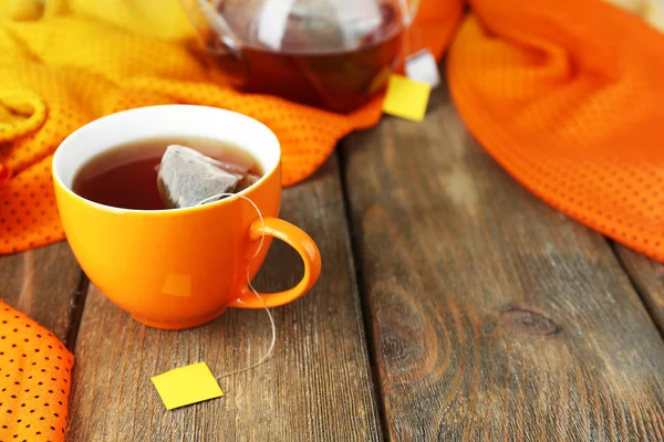 Taza de té, tetera y bolsitas de té en la mesa de madera de cerca — Foto de Stock