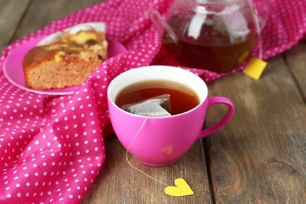 Tasse Tee, Teekanne und Teebeutel auf Holztisch in Großaufnahme — Stockfoto