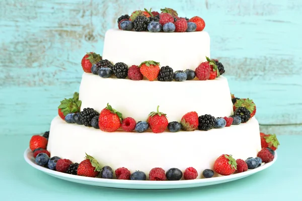Красивый свадебный торт с ягодами на фоне цвета дерева — стоковое фото