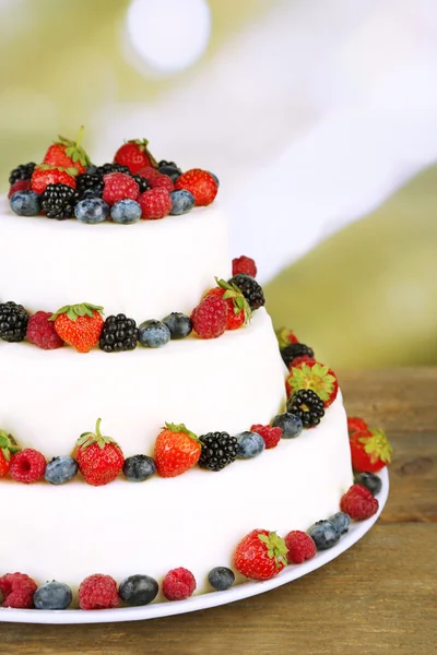 Krásný svatební dort s ovocem na dřevěný stůl, na světlé pozadí — Stock fotografie