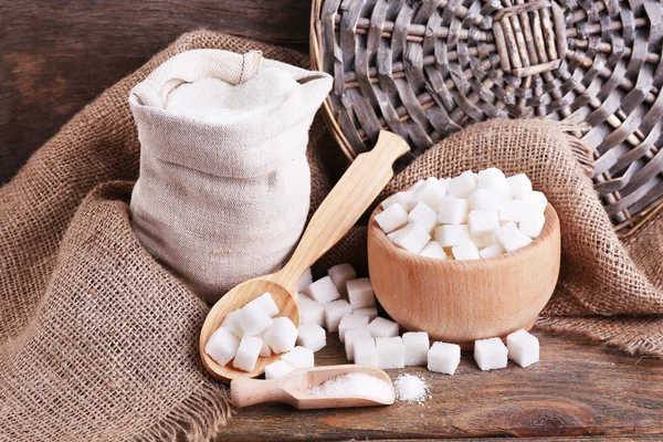 Refined sugar in bag and bowl on wooden background — Stock Photo, Image