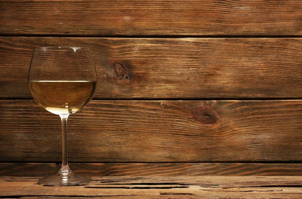 Verre de vin blanc sur table en bois sur fond mural en bois — Photo