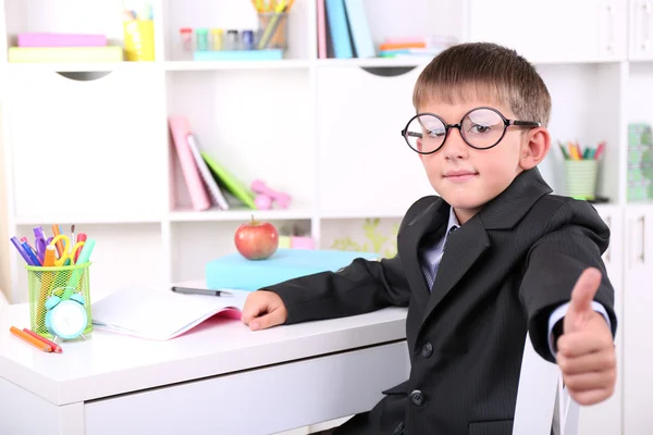 Schooljongen zitten aan tafel in klas — Stockfoto