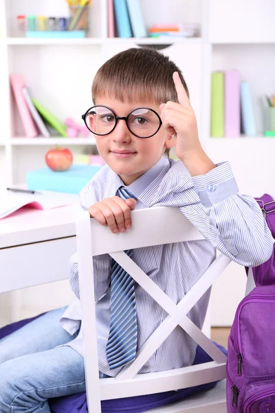 Schooljongen zitten aan tafel in klas — Stockfoto