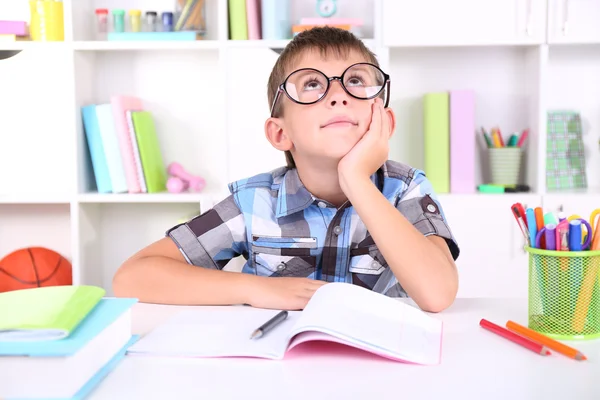 Schoolboy sitting at table in classroom — Stock Photo, Image
