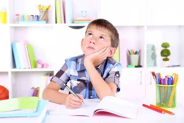 Schoolboy sitting at table in classroom — Stock Photo, Image