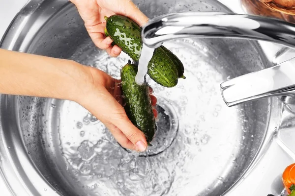 Woman's hands washing cucumbers — Stock Photo, Image