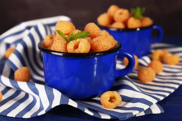 Frambuesas amarillas en tazas azules — Foto de Stock