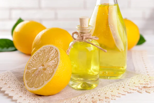 Lemon oil on table on light background — Stock Photo, Image