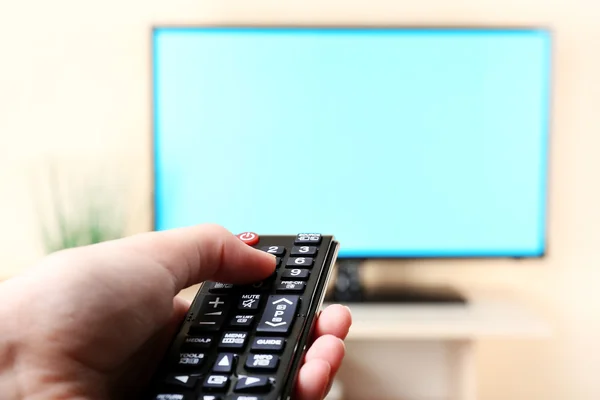 TV e usando controle remoto — Fotografia de Stock