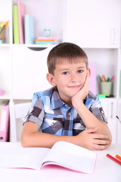 Schoolboy sitting at table in classroom Stock Image