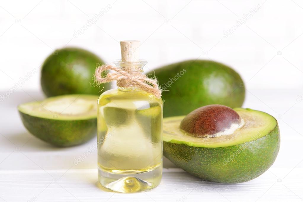 Avocado oil on table on light background