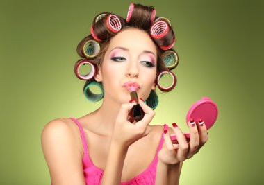 yeşil zemin üzerine saç curlers içinde güzel bir kız