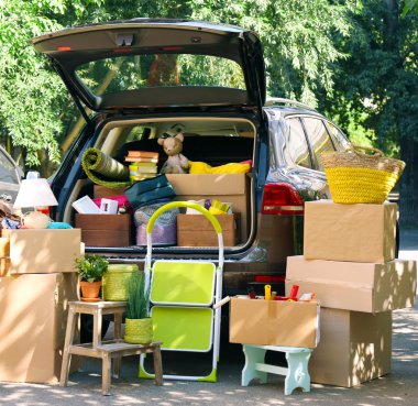 Moving boxes and suitcases in trunk of car, outdoors clipart