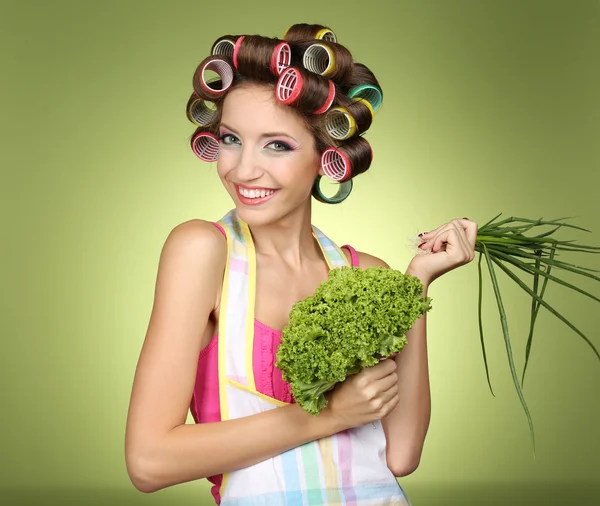 Beautiful girl in hair curlers on green background — Stock Photo, Image