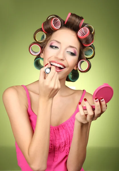 Beautiful girl in hair curlers on green background — Stock Photo, Image