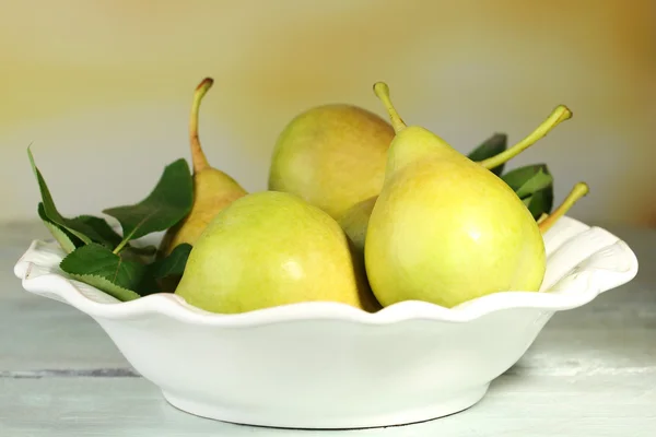 在碗里，在桌子上，对自然背景熟美味梨子 — 图库照片