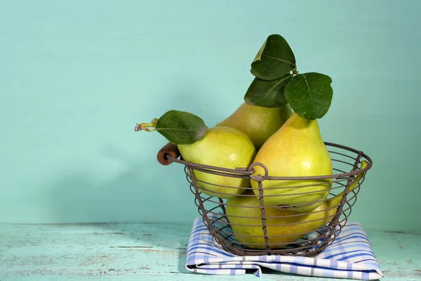 Rijp smakelijke peren in metalen mand, op houten tafel — Stockfoto