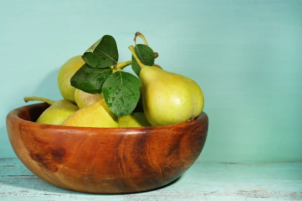 Poires mûres savoureuses dans un bol en bois, sur la table — Photo