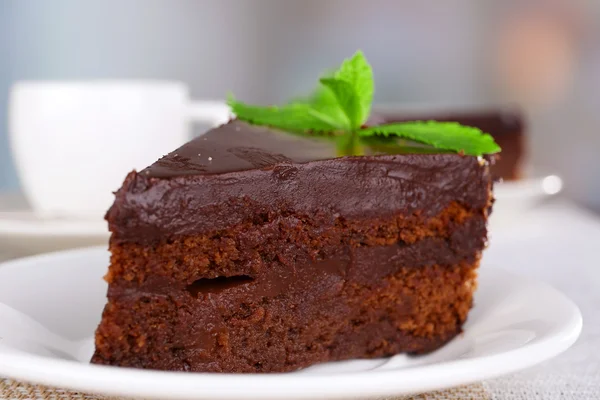 Morceaux de gâteau au chocolat sur assiettes et tasse de thé sur table sur fond naturel — Photo