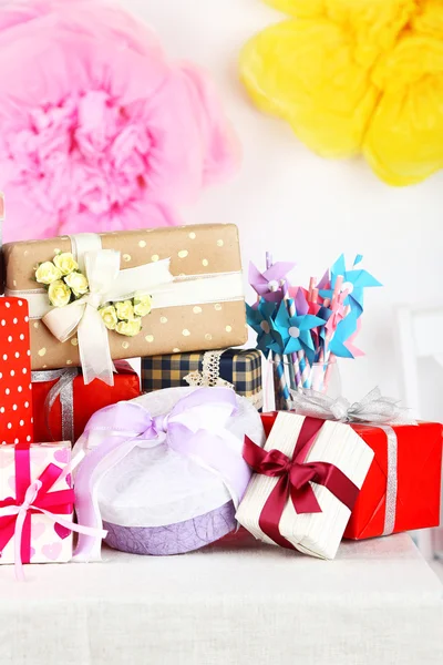 Regalos de boda o cumpleaños en la mesa decorada, sobre fondo brillante —  Fotos de Stock