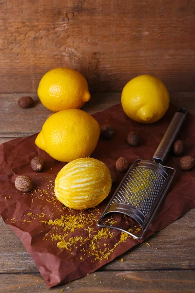 Lemons, nutmegs and grater — Stock Photo, Image