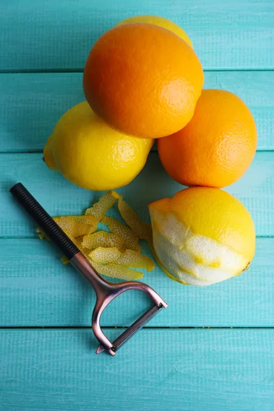 Limones y naranjas y cuchillo pelador —  Fotos de Stock