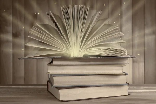 Antiquarische Bücher auf Holztisch mit warmem Licht — Stockfoto