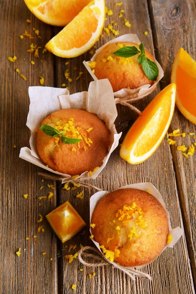 Tasty cupcakes with orange on table close-up — Stock Photo, Image