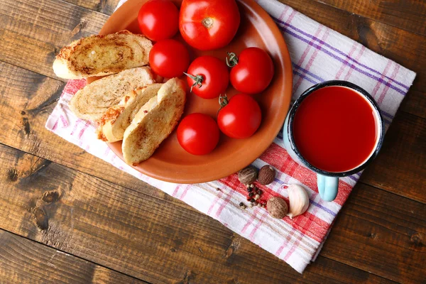 Hausgemachter Tomatensaft im Farbbecher, Toastbrot und frische Tomaten auf Holzuntergrund — Stockfoto