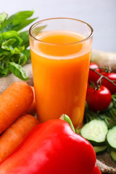 Bicchiere di succo di carota fresco e verdure su tovagliolo di licenziamento su tavolo di legno — Foto Stock