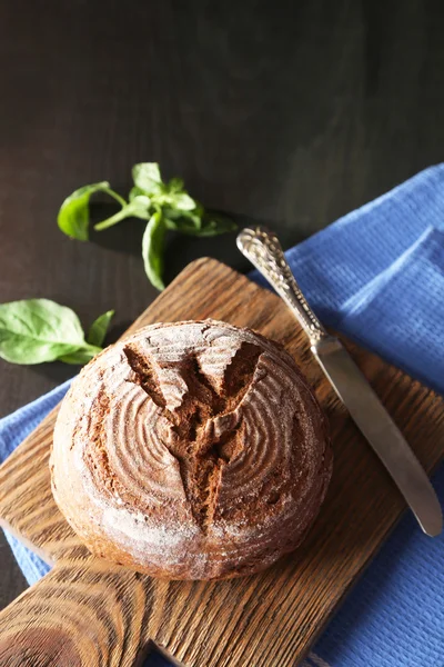 Taze pişmiş ekmek ve ahşap zemin üzerinde kesme tahtası üzerinde taze fesleğen — Stok fotoğraf