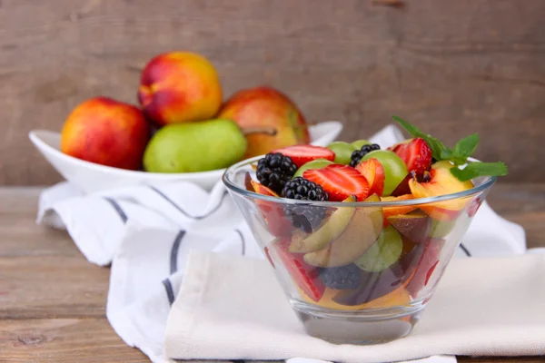 Lekkere en verse fruitsalade op houten tafel — Stockfoto