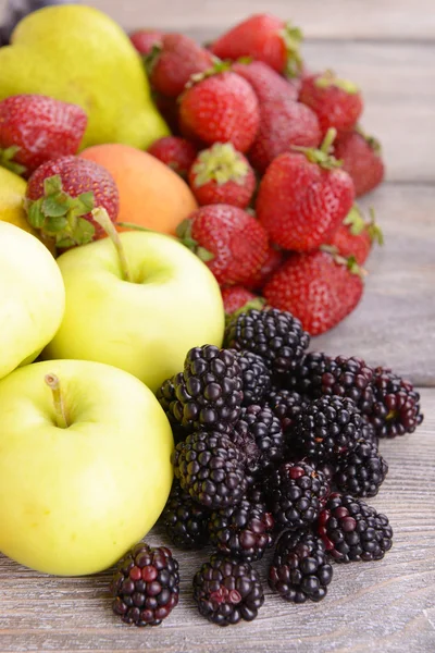 Buah-buahan dan buah-buahan matang dengan latar belakang kayu — Stok Foto
